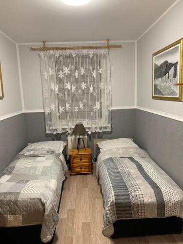 a bedroom with two beds and a window at Apartament Aria in Ełk