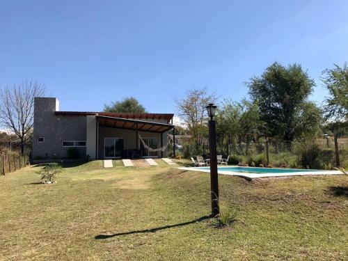 a house with a swimming pool in the yard at Casa en Potrero de Garay con pileta in Potrero de Garay