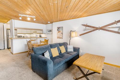 a living room with a blue couch and a table at A Scent of Pine in Steamboat Springs