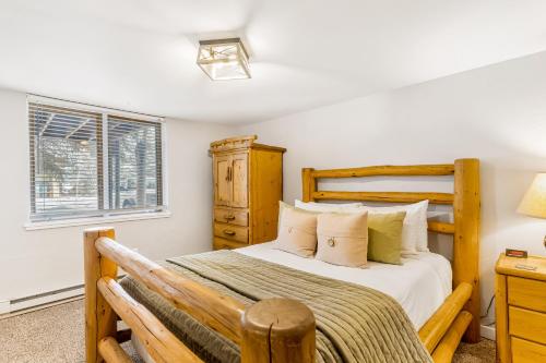 una camera con letto in legno e finestra di A Scent of Pine a Steamboat Springs