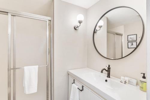a white bathroom with a sink and a mirror at A Scent of Pine in Steamboat Springs