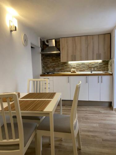 a kitchen with a wooden dining table and chairs at Casas La Aldea Suites Plaza in La Aldea de San Nicolas