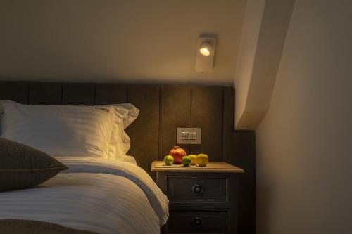 a bed with a night stand with fruit on it at La Boheme Boutique Casa Soare in Bucharest