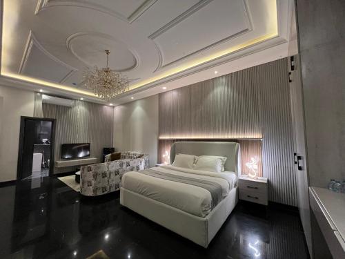 Un dormitorio con una cama grande y una lámpara de araña. en Arayik Resort, en Taif