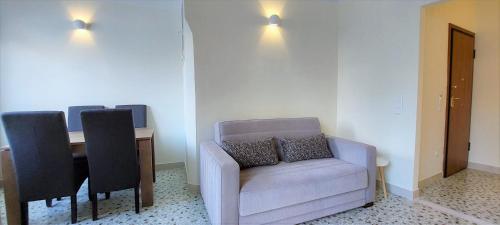 een woonkamer met een bank en een tafel met stoelen bij Athens Plaka Family Suites in Athene