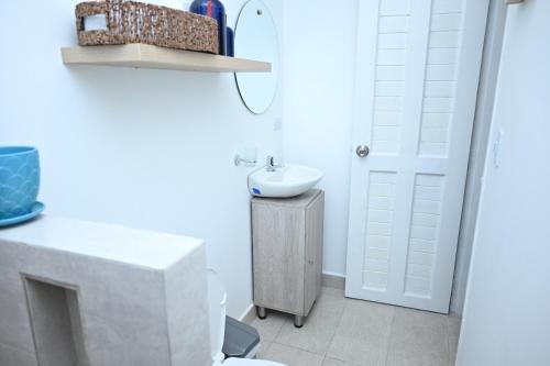 a white bathroom with a sink and a toilet at Quinta del Mar Crystal Beach in Tintipan Island