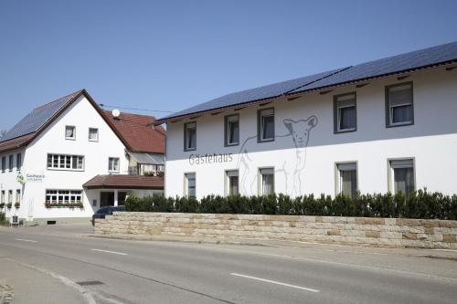 ein weißes Gebäude an der Straßenseite in der Unterkunft Gästehaus und Fewo Lamm Garni in Blaubeuren