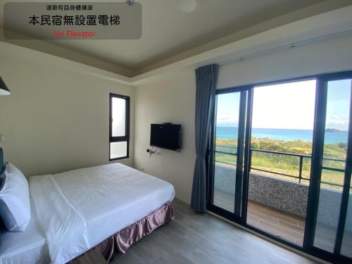 a bedroom with a bed and a view of the ocean at 三仙台日出民宿 in Chenggong