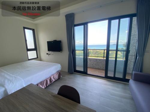 a hotel room with a bed and a large window at 三仙台日出民宿 in Chenggong
