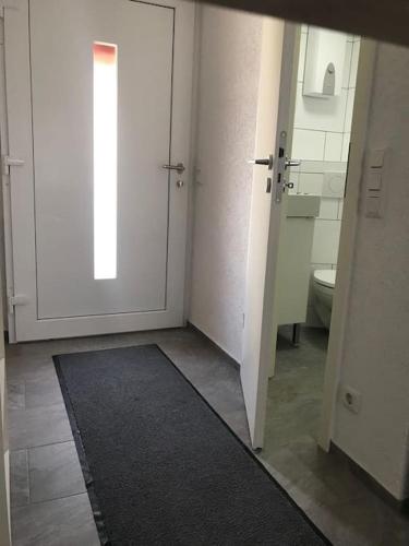 a bathroom with a white door and a toilet at Modernisiertes Gästezimmer im Ortskern in Wehrheim