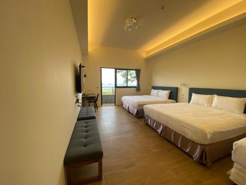 a hotel room with two beds and a window at 三仙台日出民宿 in Chenggong