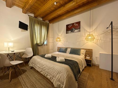 a bedroom with a bed and a table and a desk at Agriturismo Vecio Portico in Marostica