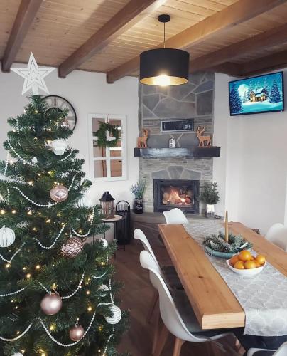 a christmas tree in a living room with a fireplace at Osada wspomnień in Polańczyk