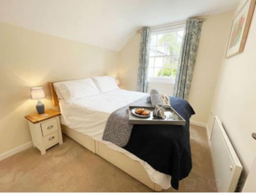 a bedroom with a bed with a tray of food on it at Waypast, Port Isaac Bay Holidays in Port Isaac