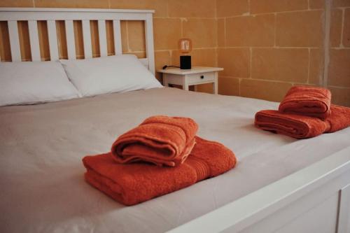 クレンディにあるSeaview 2-bedroom Apartment in Xlendiのベッドの上に座るタオル2枚