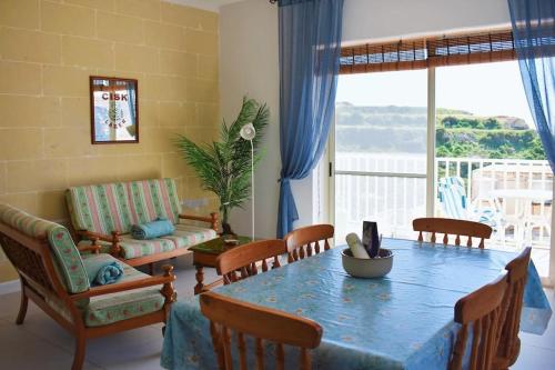 a living room with a table and a couch at Seaview 2-bedroom Apartment in Xlendi in Xlendi
