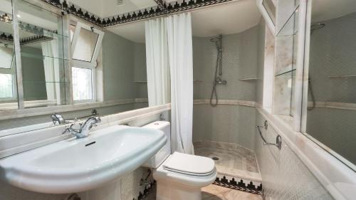 bagno con lavandino, servizi igienici e specchio di Sao Rafel Beach house ad Albufeira