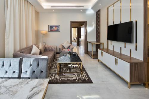 a living room with a couch and a tv at Gladiolus Hotel in Jeddah