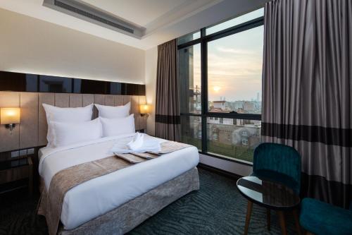 um quarto de hotel com uma cama e uma grande janela em Gladiolus Hotel em Jidá