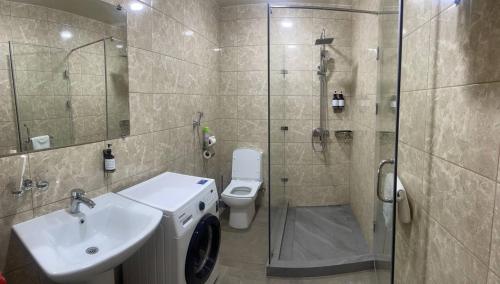 a bathroom with a shower and a sink and a toilet at Tashkent City View Apart in Tashkent