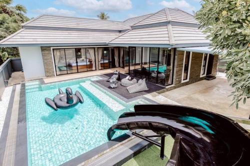 a swimming pool with people in a house at Onyx Stay Pool Villa @Pranburi in Ban Nong Sua