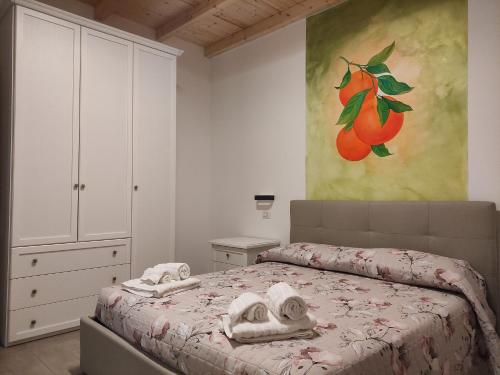 a bedroom with a bed and a painting of oranges at Agriturismo Ariston ONC 1484 in Sabaudia