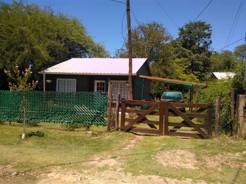 una casa con una puerta de madera y una valla en Cabaña VGB. en Villa General Belgrano