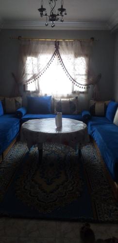 a living room with a table in front of a window at agadir hassania in Agadir