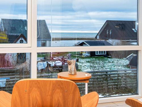 a room with a large window with a table and a vase at 10 person holiday home in Glesborg in Bønnerup
