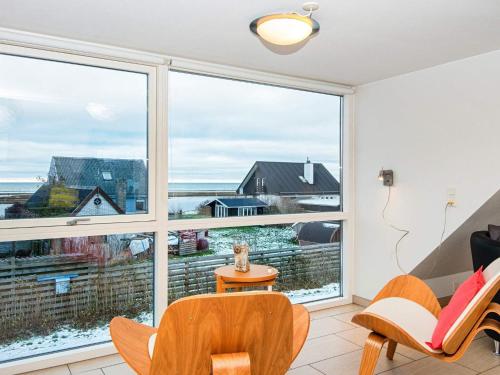 ein Wohnzimmer mit einem großen Fenster sowie einem Tisch und Stühlen in der Unterkunft 10 person holiday home in Glesborg in Bønnerup