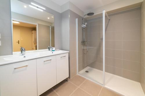 uma casa de banho com um chuveiro, um lavatório e um WC. em Les coursives appartements em Mâcon