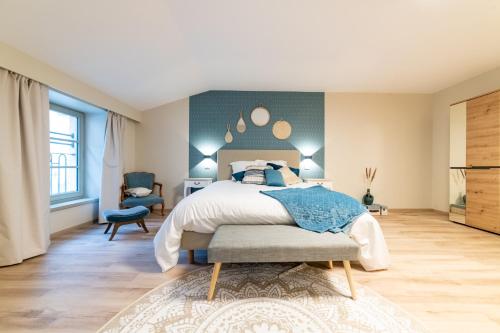 a bedroom with a bed and a blue wall at Les coursives appartements in Mâcon
