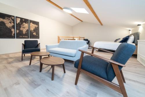 a living room with a couch and a bed and chairs at Les coursives appartements in Mâcon