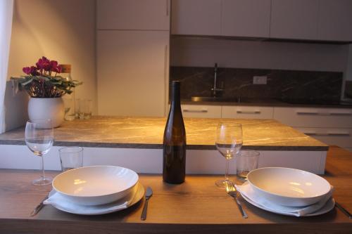 einen Tisch mit 2 Tellern und eine Flasche Wein in der Unterkunft Ansitz von Wohlgemuth in Salurn