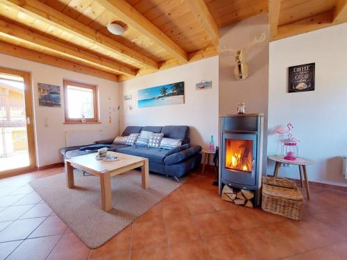 a living room with a couch and a fireplace at Casa Cubana - Schönes und komfortables Ferienhaus am Waldrand in Lechbruck