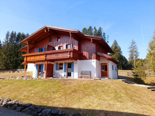 a house on top of a grassy hill at Casa Cubana - Schönes und komfortables Ferienhaus am Waldrand in Lechbruck