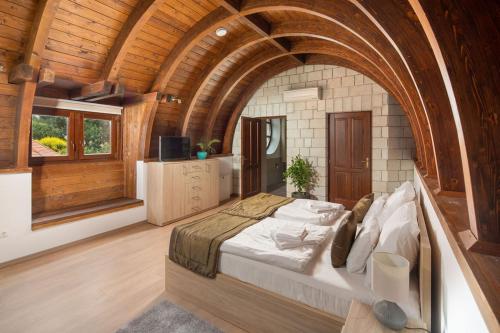 Un dormitorio con una cama grande en una habitación con techos de madera. en Furmint Ház, en Mád
