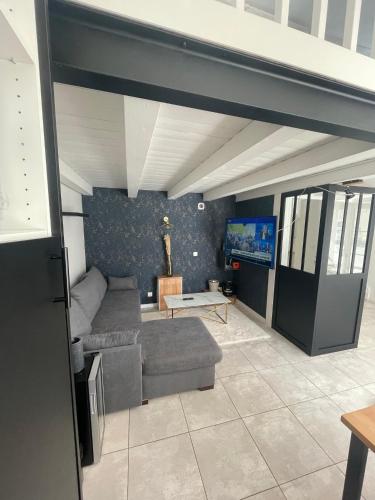 un salon avec un canapé et une télévision dans l'établissement Maisonnette, à Sainte-Soulle