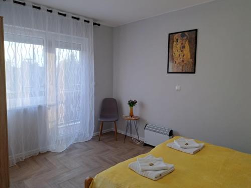 a bedroom with a yellow bed and a window at Apartments Manna Palic in Palić