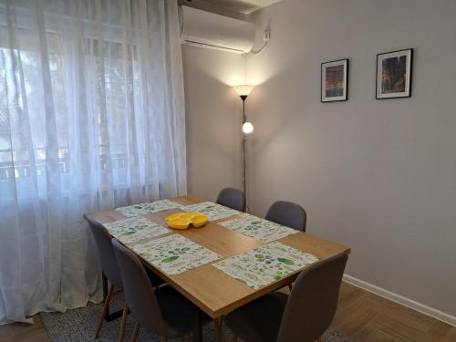 a dining room table with chairs and a lamp at Apartments Manna Palic in Palić