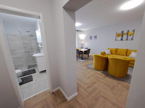 - un salon avec un canapé jaune et une table dans l'établissement Apartments Manna Palic, à Palić