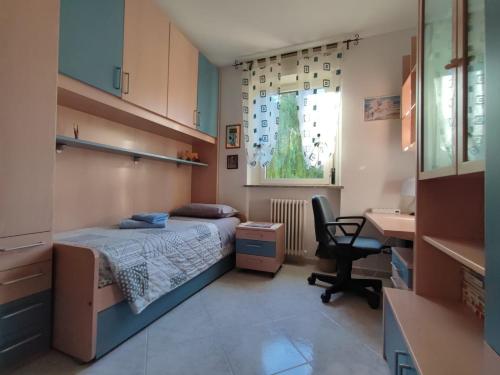 een slaapkamer met een bed, een bureau en een stoel bij Singola in famiglia (MyAostaProject - Rentals) in Aosta