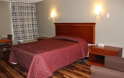ein Schlafzimmer mit einem Bett mit einer roten Decke darauf in der Unterkunft Araamada Inn in Albany