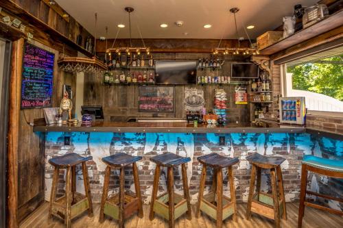 a bar with stools in a room with wood at Adventure Suites in North Conway