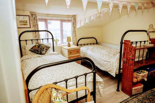 a bedroom with two beds and a window at Spacious Charming Cottage near Lake and Sea in Hornsea
