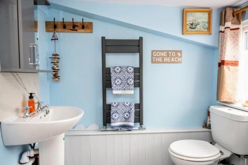 ein Badezimmer mit einer weißen Toilette und einem Waschbecken in der Unterkunft Spacious Charming Cottage near Lake and Sea in Hornsea