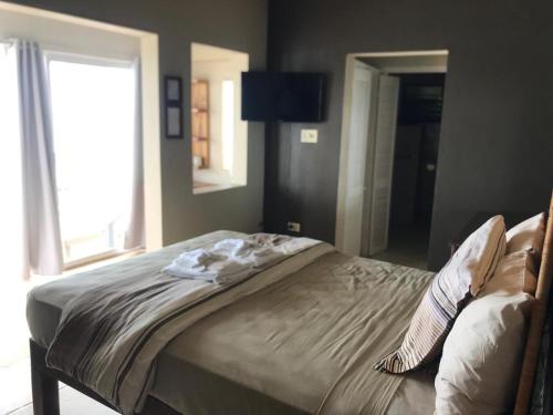 a large bed in a bedroom with a window at Moxons Beach Club in Boscobel