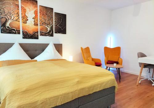 a bedroom with a large bed and two chairs at Living-Life, Klinik & Messe vor Ort, Wlan, Netflix in Essen