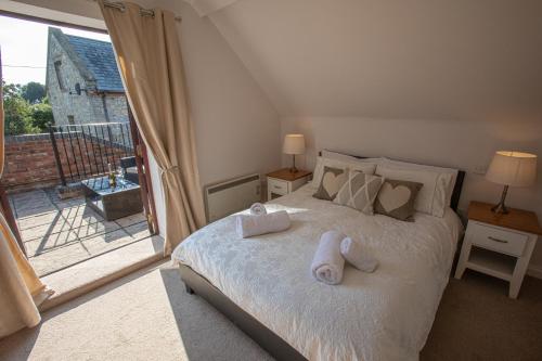 1 dormitorio con 1 cama con toallas en Newclose Farm Cottages, en Yarmouth