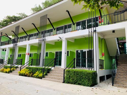 an office building with green walls and stairs at Somrudee Resort in Nakhon Nayok